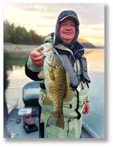 Angler holding a smallmouth bass on a boat
